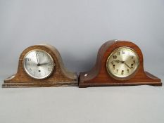 A Napoleons hat mantel clock with carved detailing, Arabic numerals to the dial,