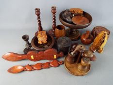 A collection of treen to include candlesticks, carved animal trinket boxes, love spoons and similar.