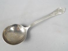 An Italian ladle with scrolling floral decoration to the handle, stamped .