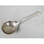 An Italian ladle with scrolling floral decoration to the handle, stamped .