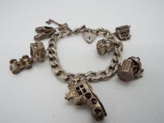 A silver charm bracelet containing seven charms