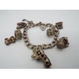 A silver charm bracelet containing seven charms