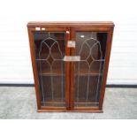 A twin door glazed bookcase measuring approximately 95 cm x 73 cm x 22 cm.