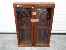 A twin door glazed bookcase measuring approximately 95 cm x 73 cm x 22 cm.