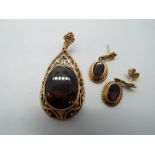 A 9ct gold stone set pendant with matching earrings (one is lacking the butterfly),