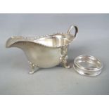 A George V hallmarked silver sauce boat, Birmingham assay 1915 and a hallmarked silver napkin ring,