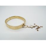 A hallmarked 9ct yellow gold bangle with safety chain and chased,