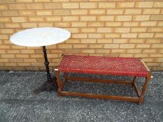 A garden table with cast iron base and marble top,
