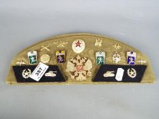 A collection of eighteen Russian military badges displayed on a Russian military beret together