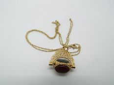A 9ct gold fine chain with semi precious, triple stone set fob pendant, approximately 3.