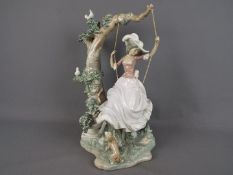 Lladro - A large Lladro figure group depicting a girl on a swing,