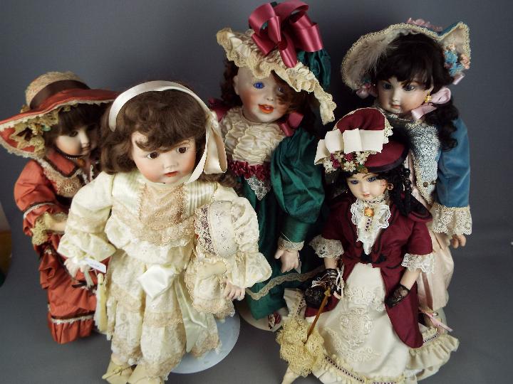 A collection of five beautifully costumed dolls, porcelain heads and hands and fixed glass eyes.