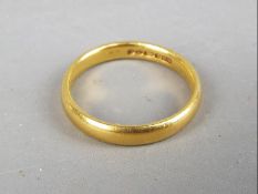 A hallmarked 22ct gold wedding band, size J, approximately 3.33 grams all in.