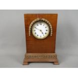 A mantel clock with carved detailing to the case, Roman numerals to enamel dial and French movement,