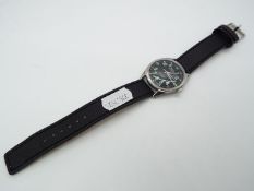 A military style wristwatch, black dial with green numerals marked hmt,