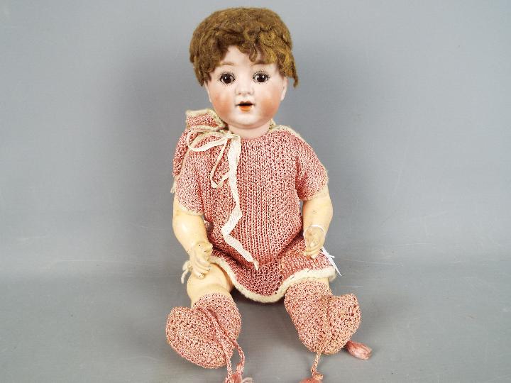 A Schoenau & Hoffmeister character doll with bisque head with sleeping brown eyes, composition body,