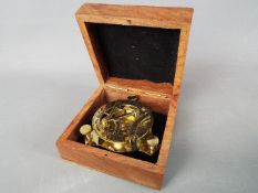 A boxed brass sundial compass,