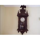 A Vienna style wall clock, opening glazed door flanked by turned columns,