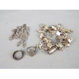 A charm bracelet with various silver and white metal charms,