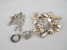 A charm bracelet with various silver and white metal charms,