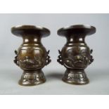A pair of twin handled bronze vases, with bird and turtle decoration, white metal inlay,