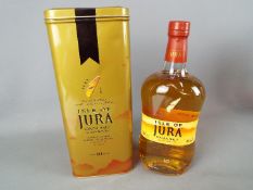 A bottle of Jura 10 year old 70 cl 40% ABV in presentation tin