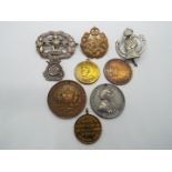 A small collection of military cap badges and similar to include Royal Armoured Corps,