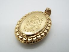 A hallmarked 9ct yellow gold locket with engraved decoration, 4.5 cm x 3.5 cm and approximately 17.