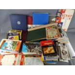 A collection of vintage ordnance survey maps, scrap books, stamps, cricket score books, postcards,