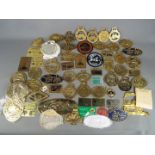 A box of steam fair and rally plaques, badges and similar, predominantly brass.