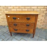 A chest of three drawers raised on four supports, approximately 77 cm x 84 cm x 45 cm.