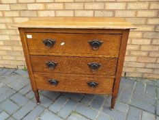 A chest of three drawers raised on four supports, approximately 77 cm x 84 cm x 45 cm.