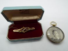 A stone set bar brooch, stamped 9ct, with safety chain, approximately 2.