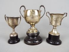 A small collection of trophies, the first a George VI silver, twin handled example,