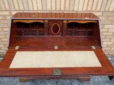 A Georgian writing bureau with two over three drawers and having fitted interior with secret