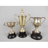 Three small trophies comprising two twin handled silver examples, one London assay,