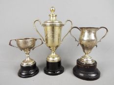 Three small trophies comprising two twin handled silver examples, one London assay,