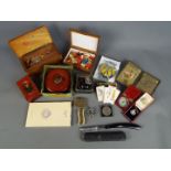 A mixed lot of collectables to include trinket boxes, gaming tokens, cigarette lighters,