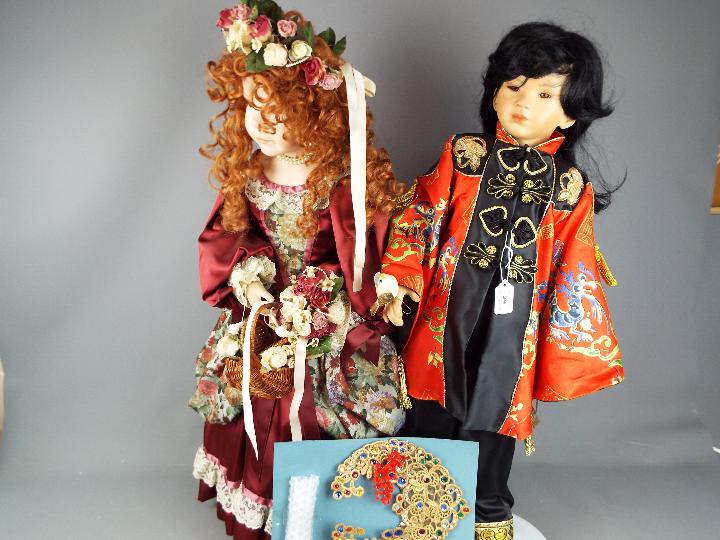 Dolls - one dressed in traditional Chinese silk costume and another,