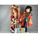 Dolls - one dressed in traditional Chinese silk costume and another,