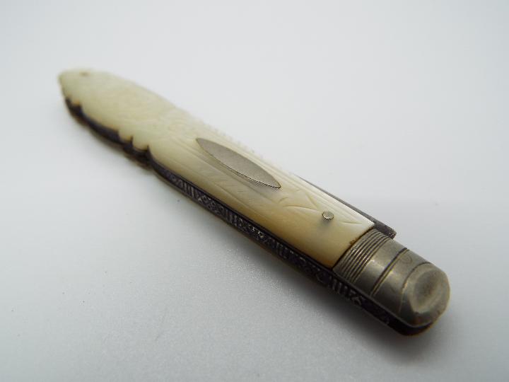 An Edward VII silver and mother of pearl folding fruit knife with floral decoration to the handle,