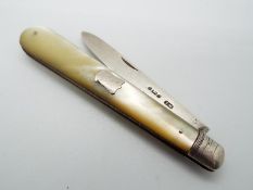 A Victorian silver and mother of pearl folding fruit knife, vacant cartouche to the handle,