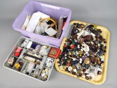 A box of sewing accessories and a large quantity of buttons.