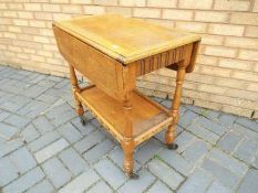 A drop leaf trolley approximately 74 cm