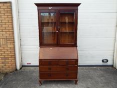 A bureau bookcase with twin glazed doors, approximately 210 cm x 113 cm x 46 cm.