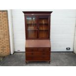 A bureau bookcase with twin glazed doors, approximately 210 cm x 113 cm x 46 cm.