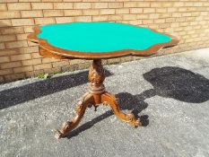 A folding card table on highly carved tripod base,