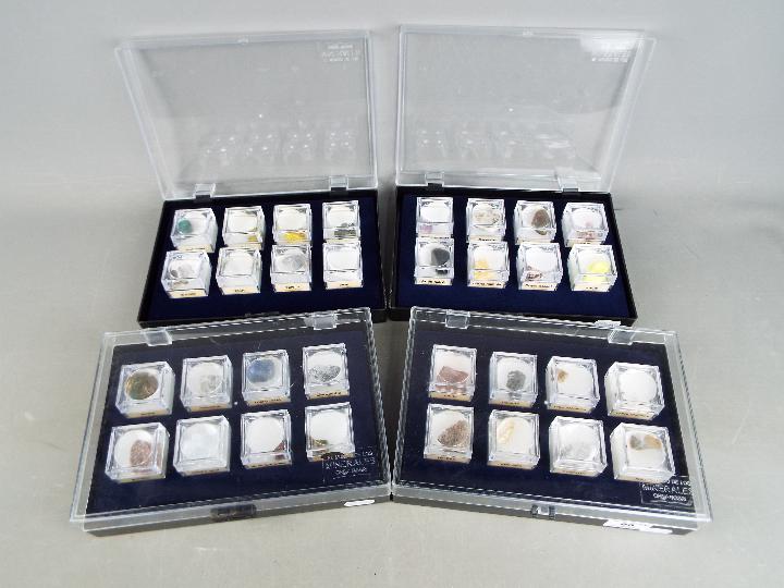 Four display cases, each containing eight boxed mineral samples with labels of origin.