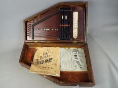 A cased autoharp with song books.