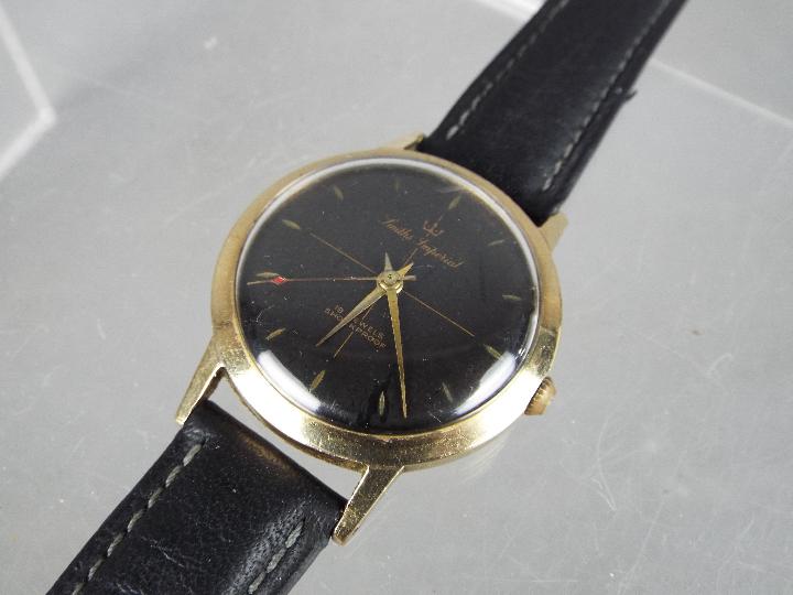 A gentleman's, yellow metal, Smiths Imperial wristwatch with black dial and 19 jewel movement,